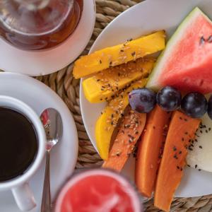 a plate of fruit and vegetables and a cup of coffee at Santa Maria Atins in Atins