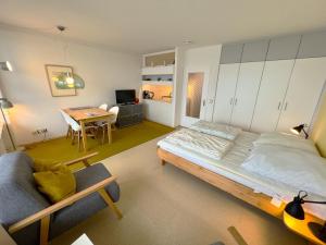 ein Wohnzimmer mit einem Bett und einem Tisch in der Unterkunft Ferienpark Sierksdorf App 323 - Strandlage in Sierksdorf