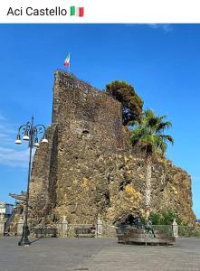 Una gran pared de piedra con un árbol encima. en HAPPY HISTORIC HOUSE, en Catania 20 fotos más