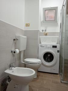 Un baño con inodoro y lavadora. en HAPPY HISTORIC HOUSE, en Catania