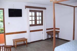 een slaapkamer met een bed en een tv aan de muur bij Hotel Mahavelo in Antananarivo