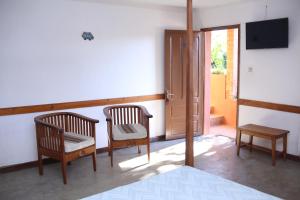 a room with two chairs and a tv and a door at Hotel Mahavelo in Antananarivo