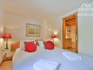 a bedroom with a large white bed with red pillows at Appartement Le Grand-Bornand, 5 pièces, 8 personnes - FR-1-391-10 in Le Grand-Bornand
