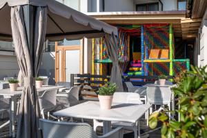 - un ensemble de tables et de chaises sur une terrasse dans l'établissement Ultra All Inclusive Apartament w Amber Park Spa, à Niechorze