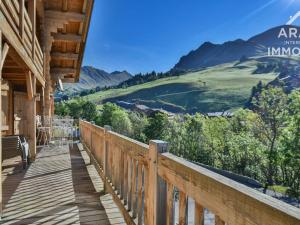 a wooden balcony with a view of the mountains at Chalet Le Grand-Bornand, 10 pièces, 18 personnes - FR-1-391-29 in Le Grand-Bornand