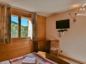 a bedroom with a bed and a tv on the wall at Chalet Le Grand-Bornand, 10 pièces, 18 personnes - FR-1-391-29 in Le Grand-Bornand