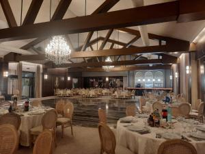 a restaurant with white tables and chairs and a chandelier at Casa Domnească Cacica in Cacica