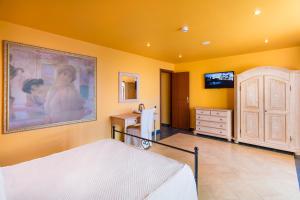 1 dormitorio con 1 cama y una pintura en la pared en Hotel La Playa Blanca, en Santo Stefano di Camastra