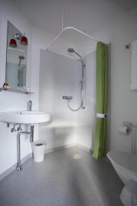 a white bathroom with a shower and a sink at Hotel Tórshavn in Tórshavn