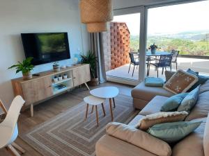 sala de estar con sofá, TV y mesa en Vistas al mar y con jardín - Casa Abelia, en Canales