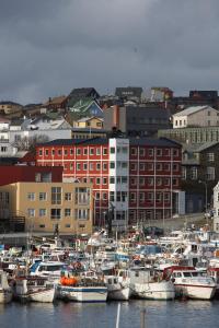 a bunch of boats are docked in a harbor at Hotel Tórshavn in Tórshavn