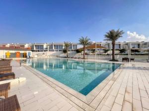 uma grande piscina com palmeiras e edifícios em Amal villa by escape time em Dubai