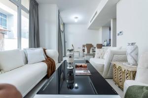 uma sala de estar com um sofá branco e uma mesa em Amal villa by escape time em Dubai