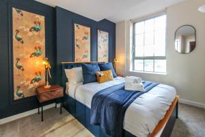 een slaapkamer met een bed met blauwe muren en een raam bij Lovely 1 Bed Apartment with Parking in Nottingham
