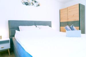 NeirivueにあるGruyère Alpes Appartement 3 chambres BBQ Parkingのベッドルーム(白い大型ベッド1台、本1箱付)