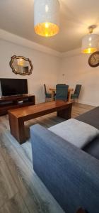 - un salon avec un canapé, une table et une télévision dans l'établissement Exchange Suites by Trinity, à Dublin
