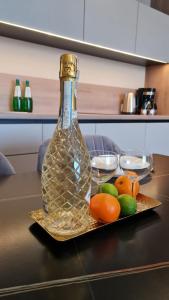 a bottle on a tray with fruit on a table at HOLIDAY HOME Bel Mare 514e in Międzyzdroje