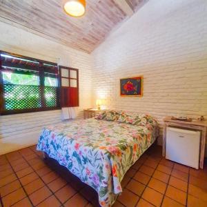 um quarto com uma cama e uma janela em Pousada do Roballo em Arraial d'Ajuda