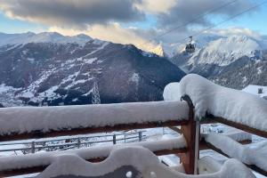 a snow covered balcony with a view of a mountain at B&B rooms within a modern family chalet with direct access to ski area in Verbier in Verbier
