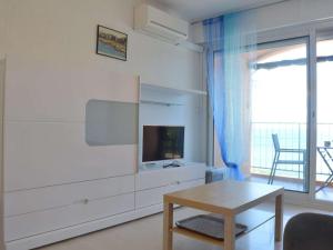 a living room with a tv and a table at Appart familial 6 pers Banyuls-sur-Mer clim, parking privé, proche plages - FR-1-225C-57 in Banyuls-sur-Mer +12 photos