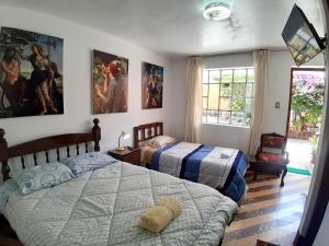 een slaapkamer met 2 bedden en een raam bij HOSPEDAJE CENTRAL in Ayacucho