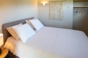 a bedroom with a bed with white sheets and pillows at B&B De Groene Driehoek 'A' in Sint Agatha