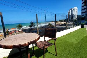 - Balcón con mesa y sillas y vistas a la playa en Flat 2 quartos, vista para o mar, en Natal