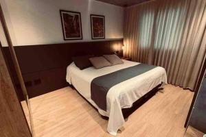 um quarto com uma cama grande num quarto em Loft de Luxo na Vila Germânica em Blumenau