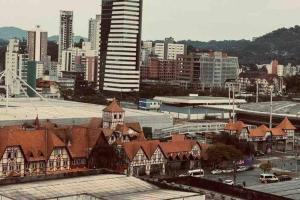 a view of a city with a tall building and buildings at Loft de Luxo na Vila Germânica in Blumenau