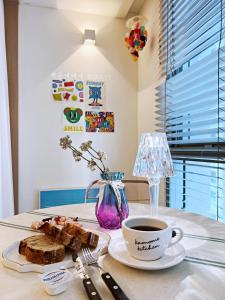 a table with a plate of bread and a cup of coffee at Haeundae Bona Travel in Busan