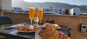 a table with two glasses of orange juice and pastries at ISLOTE in Famara