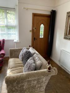 a living room with a couch with pillows on it at Knutsford Cottage in Knutsford