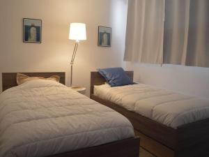 a bedroom with two beds and a lamp in it at Appartement Banyuls-sur-Mer, 3 pièces, 5 personnes - FR-1-225C-77 in Banyuls-sur-Mer
