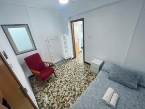 um quarto com uma cama e uma cadeira vermelha em Villa Buenavista, Costa Cálida em Águilas