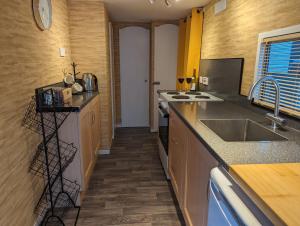 a kitchen with a sink and a counter top at The Piggery in Witheridge
