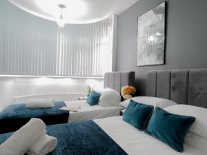 a hotel room with two beds and a couch at Tudors eSuites Four Bedroom House + Garden in Coventry