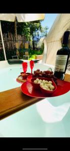 una mesa con un plato de comida y una botella de vino en Aconchego no Domo com Ofurô 7,5km centro Águas de Lindoia com CORTESIA, en Águas de Lindóia