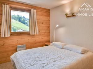 a bedroom with a large bed with a window at Appartement Le Grand-Bornand, 4 pièces, 6 personnes - FR-1-391-144 in Le Grand-Bornand