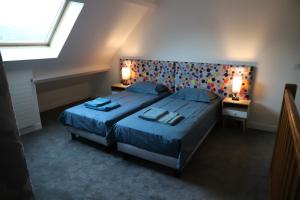 1 dormitorio con 2 camas, 2 lámparas y una ventana en Le Parc du Moulin, en Montfermeil