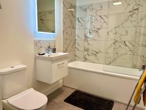 a bathroom with a toilet and a sink and a shower at House by the Sea, Worthing in Worthing