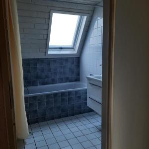 een badkamer met een bad en een raam bij De Vecht, 124 - centraal gelegen aan vijver in Gramsbergen