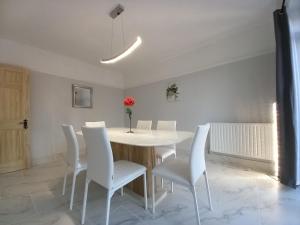 ein Esszimmer mit einem weißen Tisch und weißen Stühlen in der Unterkunft Twin home with free parkings, Surbiton, Kingston upon Thames, Surrey, Greater London, UK! in Surbiton
