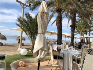 a white umbrella sitting on a table at a beach at Beachfront penthouse in Residencial Dos Mares in La Manga del Mar Menor
