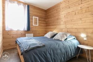 1 dormitorio con paredes revestidas de madera y 1 cama en Côté-Bourget 6 personnes LA POINTE DE LONGECOTE, proche La Norma et Aussois, en Villarodin-Bourget