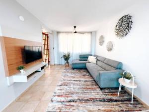 a living room with a couch and a flat screen tv at Oasis Village Spacious Apt W/ Ocean View For 9 in Rio Grande