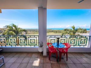a balcony with a table and chairs and a view of the ocean at Oasis Village Spacious Apt W/ Ocean View For 9 in Rio Grande