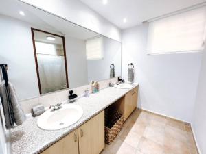 a bathroom with two sinks and a large mirror at Oasis Village Spacious Apt W/ Ocean View For 9 in Rio Grande +21 photos