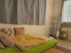ein Schlafzimmer mit einem Bett mit einer Decke darauf in der Unterkunft Rest place with beautiful flowers in Daegu
