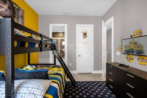 a bedroom with a bunk bed and yellow walls at Magical Vacation Home 3 min from Disney in Orlando