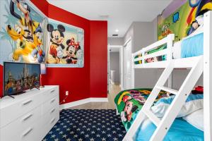 a bedroom with a red wall and a bunk bed at Magical Vacation Home 3 min from Disney in Orlando